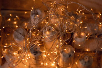 white candles with garlands in the fireplace close-up