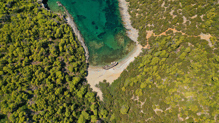 Aerial drone photo of famous small bay of Agalipa with crystal clear emerald sea featuring iconic wooden shipwreck left ashore, Skiros island, Sporades, Greece