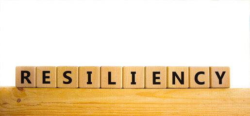 Resiliency symbol. Word 'Resiliency' written on wooden blocks. Copy space. Beautiful wooden table, white background. Business and resiliency concept.