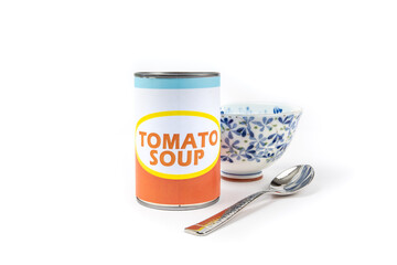 A fake generic labelled food can of tomato soup with a soup bowl and spoon isolated on white