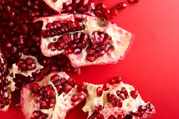 Ruby ripe fresh juicy sliced pomegranate isolated on red background