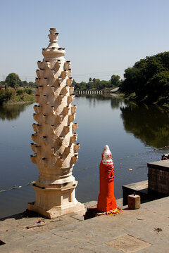 Stone lamp pillar with supports for placing earthen oil lamps on the bank of river Shipra India