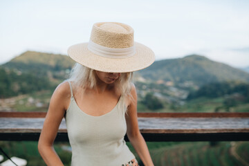 Portrait of a young woman in straw hat at viewpoint