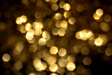 Golden blurred bokeh lights on black background. Glitter sparkle stars for celebrate. Overlay for...