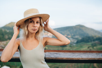 Portrait of a young woman in straw hat at viewpoint