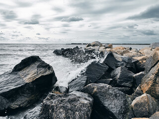 Sea waves breaking on rocks with water splashes