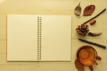 ノートを広げて、サイドにティーカップや秋の木の実等を並べた背景画像