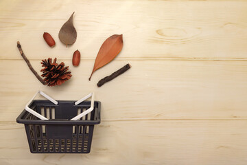 買い物かごから松ぼっくりや枯れ葉やどんぐりや小枝が飛び出すイメージ