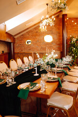 Banquet table in the restaurant, the preparation before the banquet. The work of professional florists in emerald color. Wedding, birthday, party, event concept.
