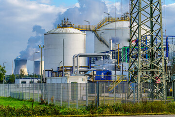 Industrieanlage mit Tankanlagen und Leitungsnetz vor Kühltürmen eines Atomkraftwerks,...