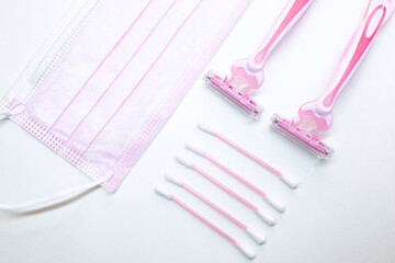 Set of disposable pink female razors, ear sticks and medical mask