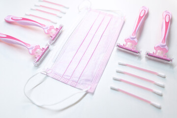 Set of disposable pink female razors, ear sticks and medical mask