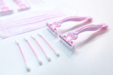 Set of disposable pink female razors, ear sticks and medical mask