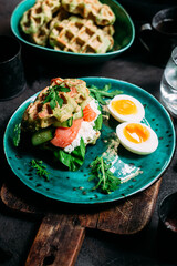 Belgian waffles with salmon, cucumber and egg in a plate