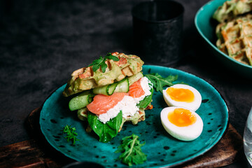 Belgian waffles with salmon, cucumber and egg in a plate
