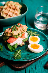 Belgian waffles with salmon, cucumber and egg in a plate