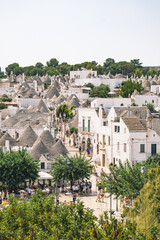 Fototapeta na wymiar Panoramic view of beautiful Trulli, traditional Apulian dry stone hut old houses with a conical roof in Alberobello, Puglia, Italy, vertical