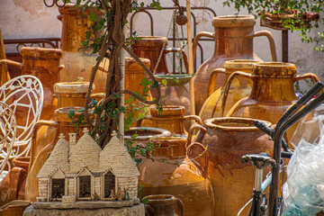 Typical Puglia ceramic jugs or jars and couple of Trulli souvenirs, traditional Apulian dry stone...