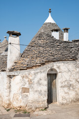 Fototapeta na wymiar Group of beautiful Trulli, traditional Apulian dry stone wall hut old houses with a conical roof in Alberobello, Puglia, Italy, vertical