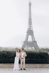 Married couple near the Eiffel tower on their wedding day. Bride and groom in Paris, France.