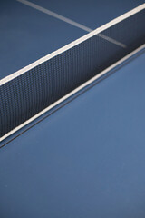 Close-up of a Ping Pong net on a blue table