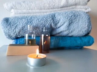 towels and candle with shower gels and homemade soap for relax