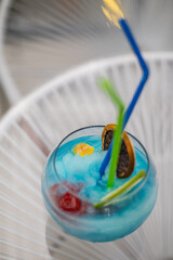 Close up of a blue cocktail on a glass with white lines