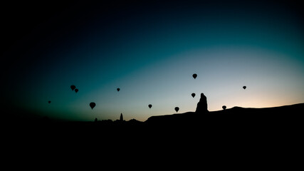 Naklejka na ściany i meble Silhouette of Fairy Chimneys and Hot Air Balloons in Cappadocia Turkey