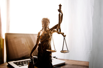 law legal technology concept. judge gavel on computer with scales of justice on desk of lawyer.