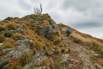 Bieszczady jesienią. Turyści na górskich szlakach. Połoniny. Ciemne chmury. Korory jesieni. © Tomasz