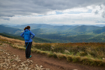 Bieszczady jesienią. Turyści na górskich szlakach. Dziewczyna spogląda w dal.Połoniny. Ciemne chmury. Korory jesieni. © Tomasz