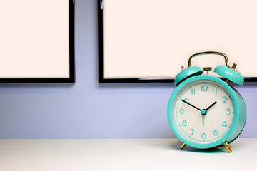 Photo of an alarm clock on a blue background. Mockup of the painting/