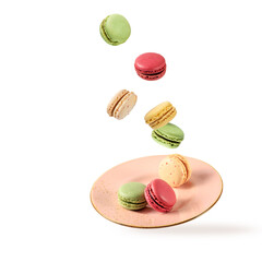 French sweet colorful cookies macarons macaroons flying falling on vintage pink plate isolated  on white background.