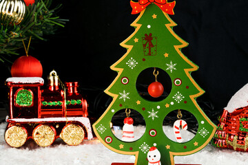 Table covered with snowflakes with Christmas decorations. Santa Claus, Christmas tree with red, gold balls and lights. Selective focus.