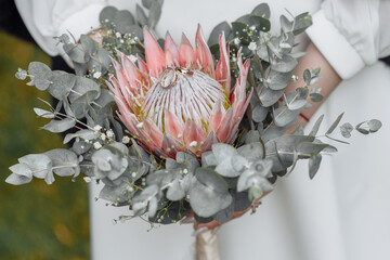 Protea flower in the wedding bouquet, beautiful wedding bouquet of protea flowers in hands of the...