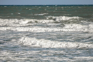 Storm at sea. Foamy water. Waves at sea. Seascape in autumn. Ocean from the side of the coast.