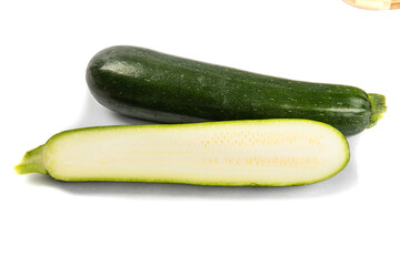 a whole green zucchini squash and a cut up zucchini showing the seeds isolated on white