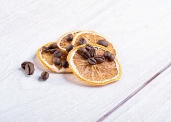 Beautiful dried oranges with coffee beans on a light wooden background