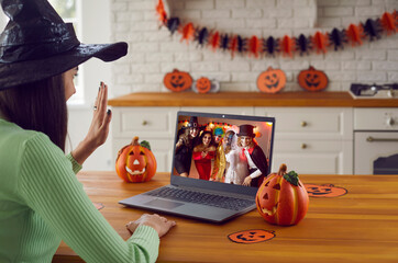 Group of people happy to see each other at virtual Halloween party. Young girl sitting in front of...