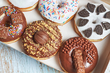 Caja de donas clásicas decoradas con diferentes topping o dulces.