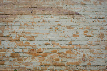 brick wall facade texture texture background. A textured background of decayed old red and white bricks in an exterior uneven wall of a house with dirty whitewashed worn plaster. Brick wall