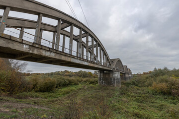 Old railway bridge over the river. Reinforced concrete bridge structure.
