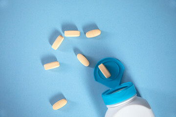 yellow drugs with bottle on table