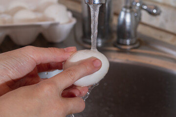 Wash chicken eggs in the kitchen sink with water and soda with your hands to disinfect eggs, kill...