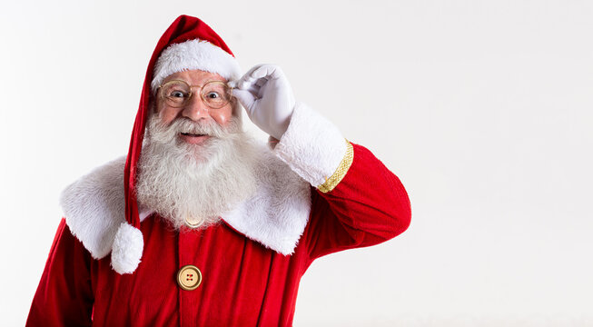 Santa Claus in eyeglasses is looking at camera and smiling, on white background