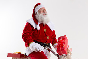 Santa Claus on bicycle delivering Christmas gifts.