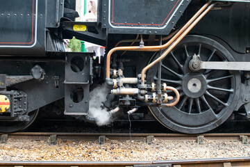 Sheringham, Norfolk, UK - SEPTEMBER 14 2019: Close-up wheels and steam from vintage Black BR Standard 4 76084 locomotive on track