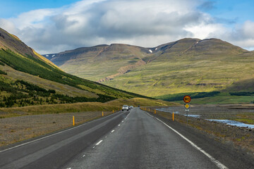 summer road trip on open hi-way  in Route 1 in Iceland with dramatic mountain landscapes on the background.
