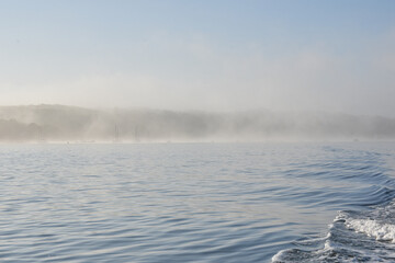 Early summer morning fog scene in Port Jefferson Harbor, Long Island, NY.  Copy space.	