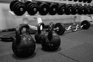 Fototapeta na wymiar kettlebell weights on rubber floor ready for strength and conditioning workout, black and white image